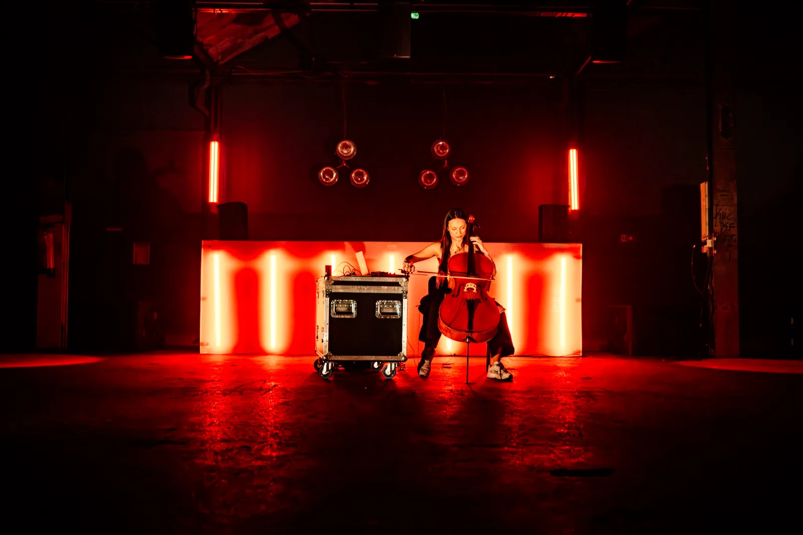 Cellistin auf einer rot beleuchteten Bühne der Haderlump-Aftershow